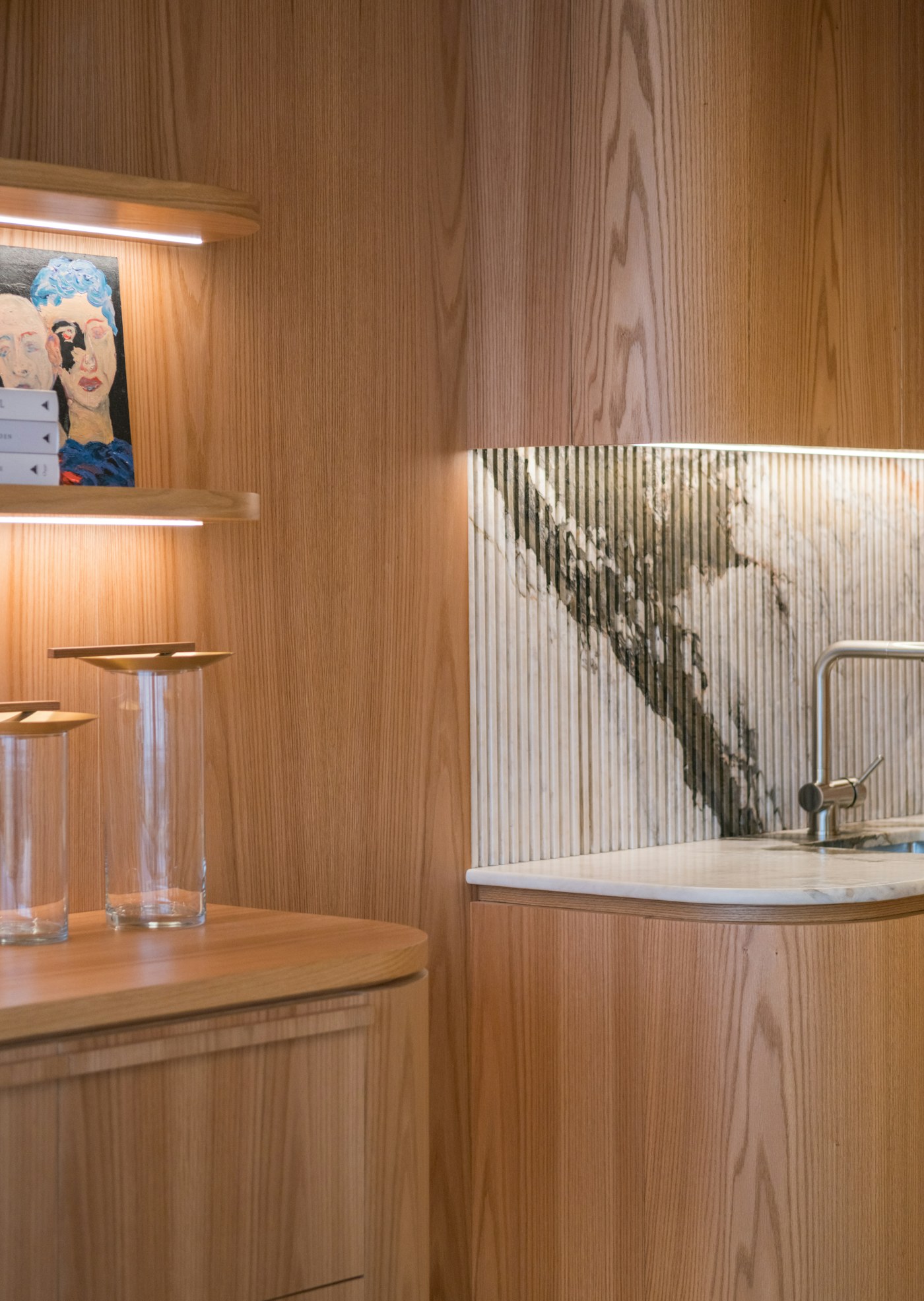 Fluted light-wood kitchen with marble worktop
